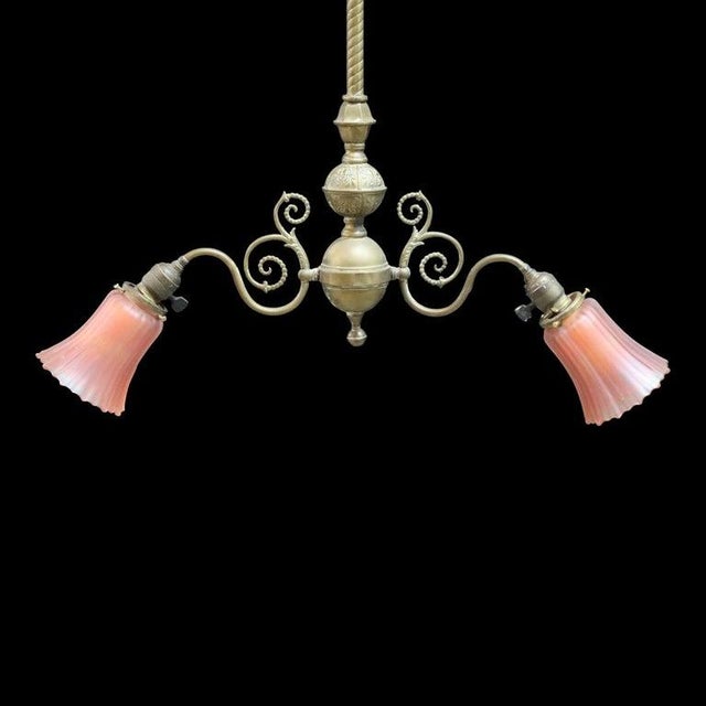 This antique Art Nouveau chandelier, dating to approximately 1910, features a brass construction with a central stem...