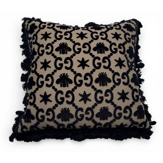 Gucci's 17-inch square pillow features GG pattern jacquard upholstery interspersed with bees and stars—codes that have...
