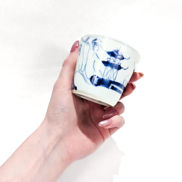 A fine Chinese export porcelain cup. In the Canton pattern. With a white ground decorated in underglaze blue. The exterior...