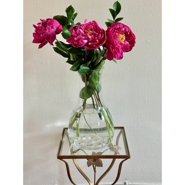 This vintage Hollywood Regency plant stand features a sculptural metal frame with a gilt finish and an ivy leaf motif. The...