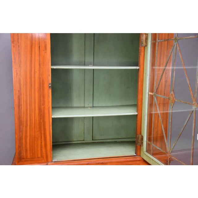 The Antique Satinwood Cabinet by T.O.P. features a single door with intricate feather plumes at the top, adding a touch of...