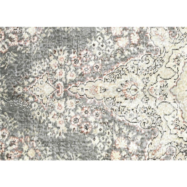 This vintage Turkish Oushak rug, measuring 6'9" by 10', is handwoven from wool on a wool foundation in the Oushak region...