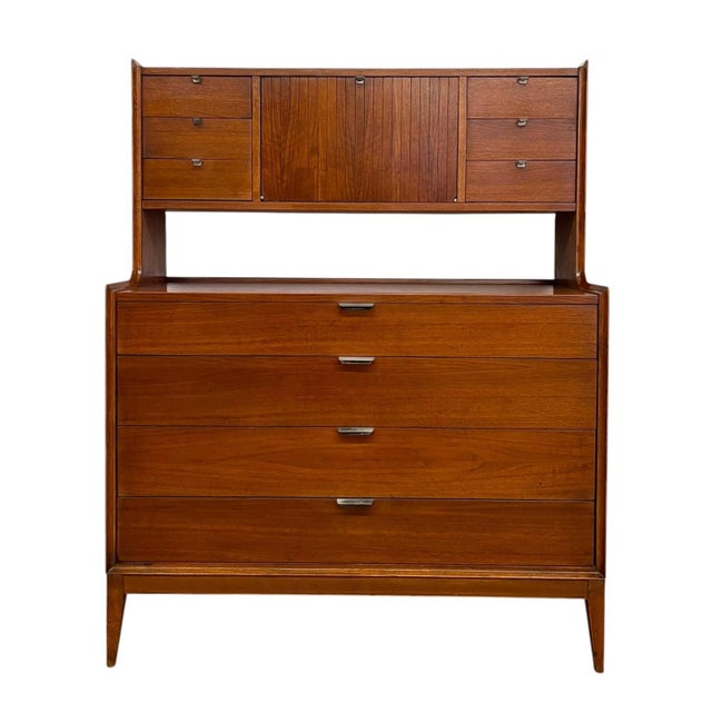 This vintage mid century modern highboy dresser by Cavalier features a functional two-tier design that combines...