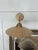 Wall-mounted sconce featuring a circular wood shade with a clear glass globe suspended beneath. The shade is flat and...