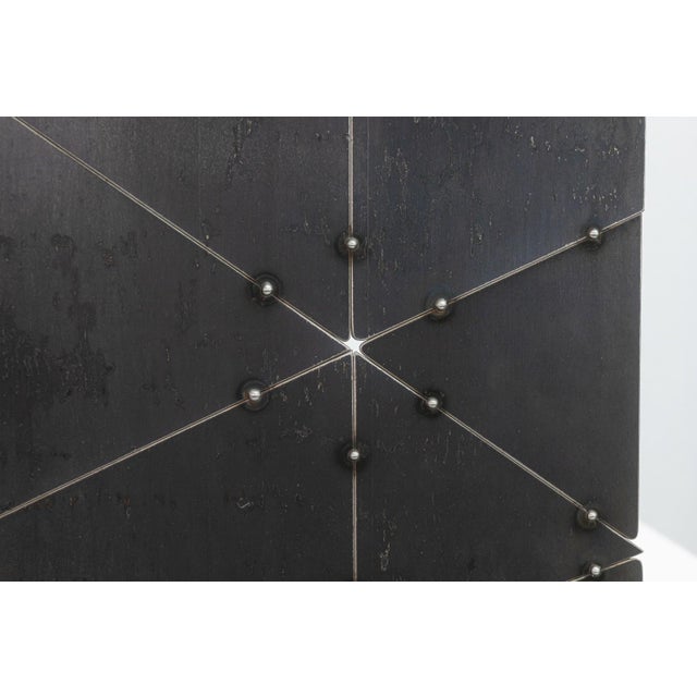 A contemporary wall sculpture by Detroit-based artist Adam Shirley is composed of intersecting metal panels joined by...