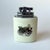 This table lighter features a cylindrical ceramic base with a glazed finish, bearing printed illustrations of a 'Daimler...