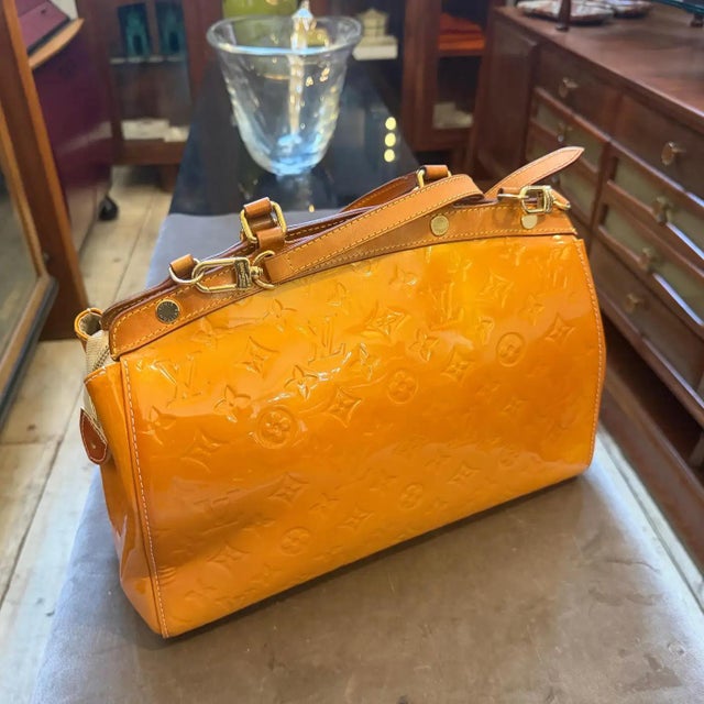 This vibrant Louis Vuitton Brea bag is crafted from striking yellow Monogram Vernis patent leather, featuring an embossed...