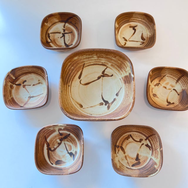 Beautiful set of seven handcrafted studio pottery bowls featuring an organic form and rich warm brown glaze with natural...