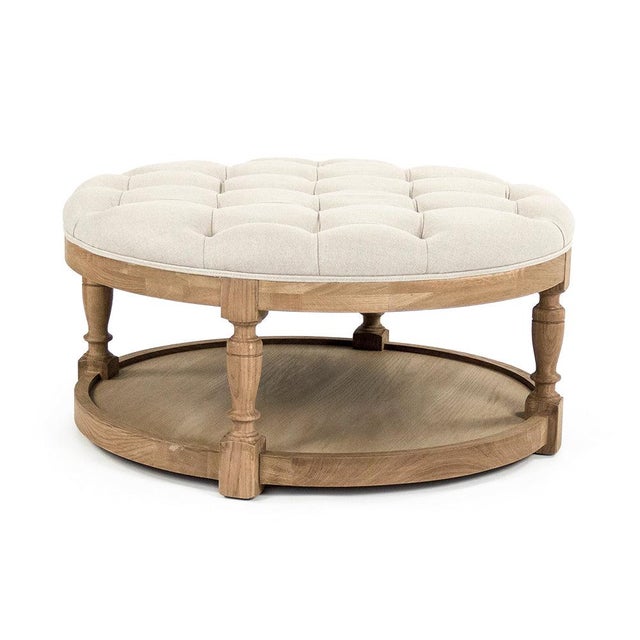 The Tammy Ottoman from Zentique is a round tufted ottoman in natural linen on a natural oak frame with turned legs. A...