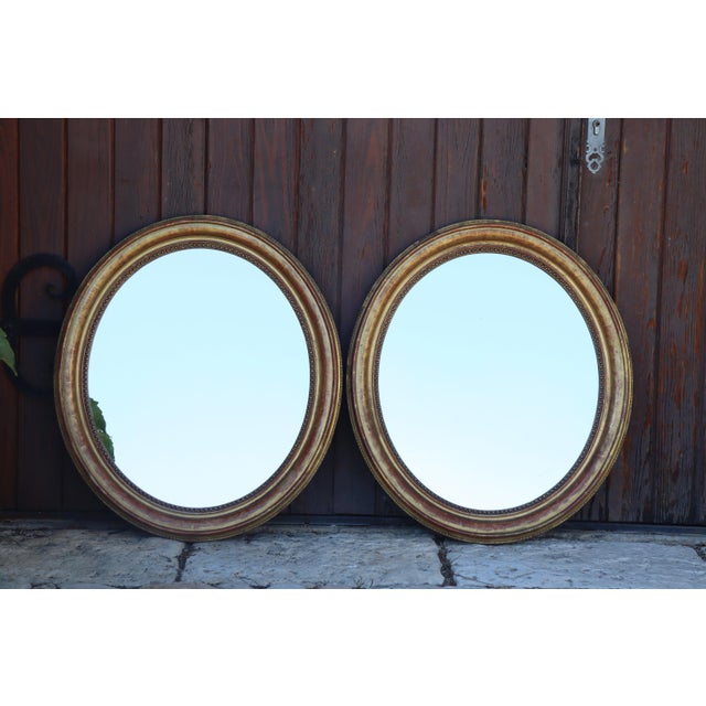 Pair of oval mirrors, Louis Philippe period, in giltwood. Very good overall condition. Engraved decoration of foliage and...