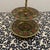 This vintage three-tiered stand is an Indian-made etched brass and enamel piece, typically dating from the 1970s. It...
