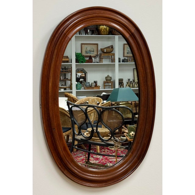 Vintage oval farmhouse style wood framed wall mirror. Features nice, rich natural wood tones with beveled frame. Age wear....