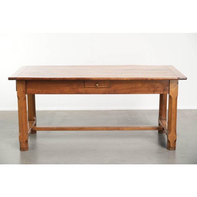 This antique French dining table features a fruitwood top and an oak base and dates from the 18th century. This...