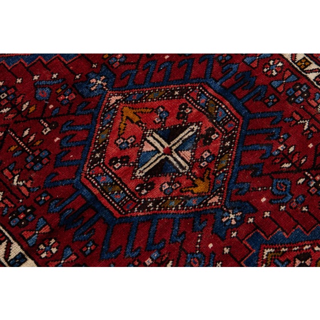 Beautiful vintage Persian Heriz hand-knotted wool runner with a navy blue field. This Persian rug has multicolor accents...