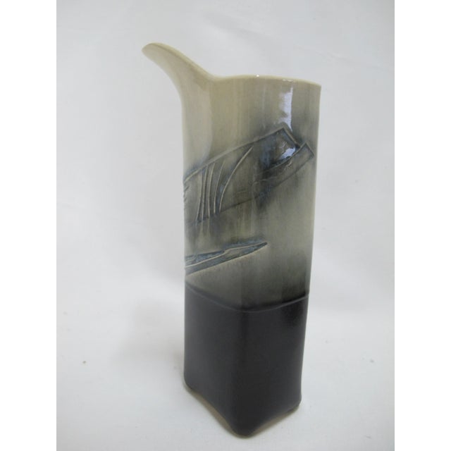 Handmade modernist Japanese studio pottery sake cup and matching pitcher. Heavily textured in deep blue tones. Both...