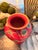 Decorative hand-painted chinoiserie-style vase featuring an elegant crimson red background accented with birds,...