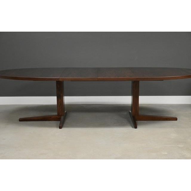 A mid century modern rosewood oval dining table with two 19.5” leaves that fully extend the table to 113.5”....