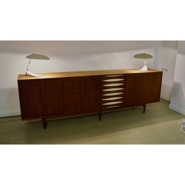 Illuminate your space with a touch of mid-century elegance with this exquisite table lamp, a stunning representation of...