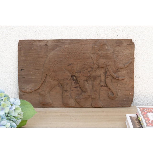 This carved wooden panel, depicting a powerful elephant, originate from Thailand and likely date to the mid-20th century...