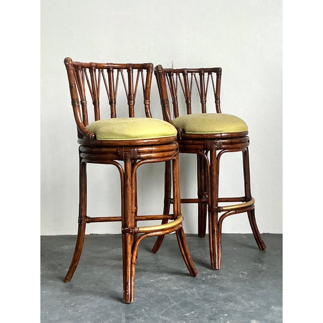 Elevate your home bar or kitchen island with this spirited pair of vintage bent rattan bar stools. Evoking the relaxed...