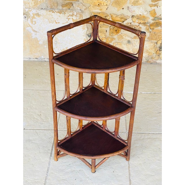 Vintage, mid-century, bamboo and rattan; three-tired corner shelf on legs, circa 1960s. this beautiful piece, has a design...