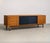 Light wood sideboard with contrasting sliding black panels. 4 drawers on the left part.