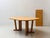 A generously sized, extendable dining table in a rustic, functional design with a clean, understated aesthetic. The...