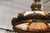 A striking Victorian style chandelier featuring a richly patinated bronze frame and domed leaded glass shade. The ornate...