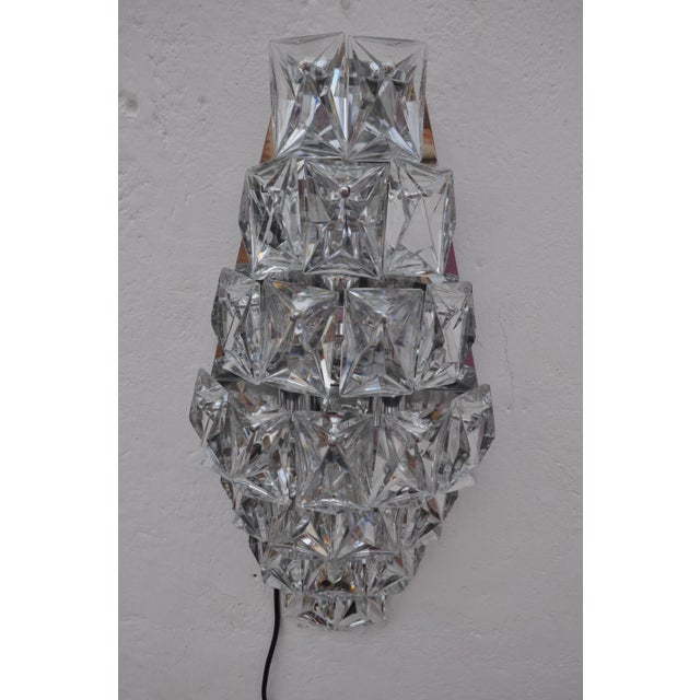 This wall light from Kinkeldey was produced in Germany in the 1960s and is composed of 23 crystals and three bulbs. The...