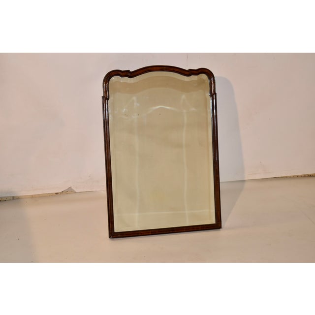 18th century Queen Anne walnut mirror with stand. The frame is wonderfully shaped and beveled in the Queen Anne style and...
