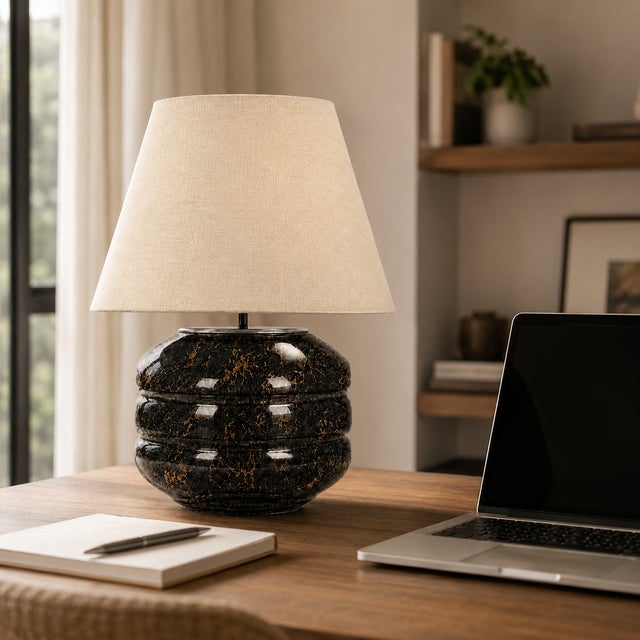 Crafted with high visual clarity, this modern table lamp features a sleek silhouette with a hand-blown glass base paired...