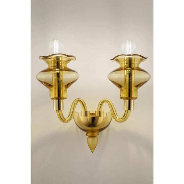 Elegant italian wall sconce in amber made in murano glass and gold plated metal frame. for classical and modern interiors,...