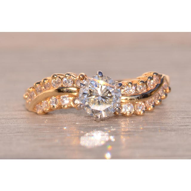 The 135th Avenue: Vintage Natural Diamond Engagement Ring in Yellow Gold. The ring centers on a six prong set 0.75 carat...