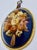 A beautifully preserved oval dried flower arrangement displayed beneath convex glass in a gilt braided frame with a velvet...