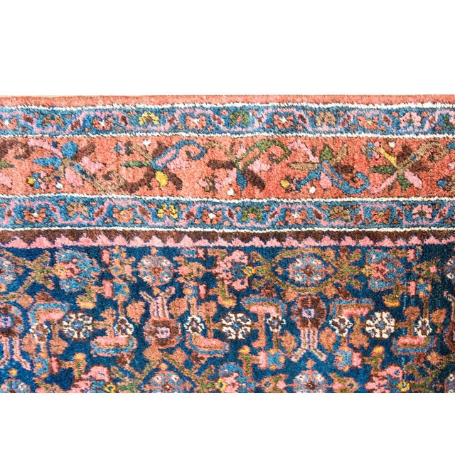 An early 20th century Persian Malayer rug with a central field with an all-over floral and leaf pattern, surrounded by a...