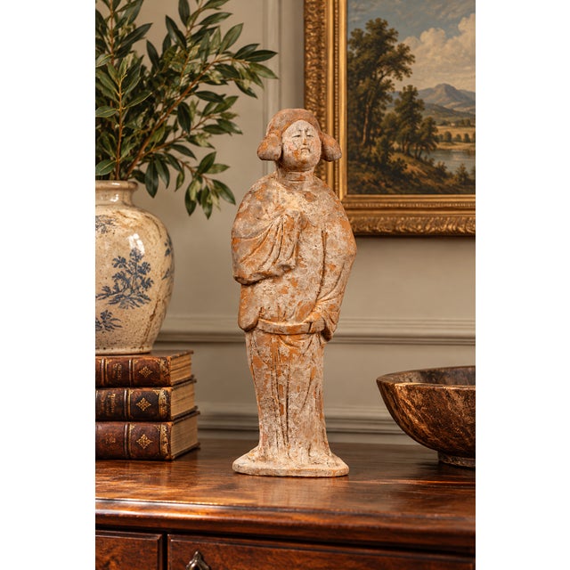 This finely modeled terracotta figure represents a standing court lady from the Chinese Tang Dynasty (618–907 AD), a...