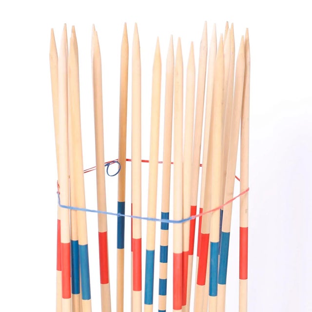 As if something from a bygone era, a larger than life set of wood pick-up sticks set to rest in a round wood base. Let the...