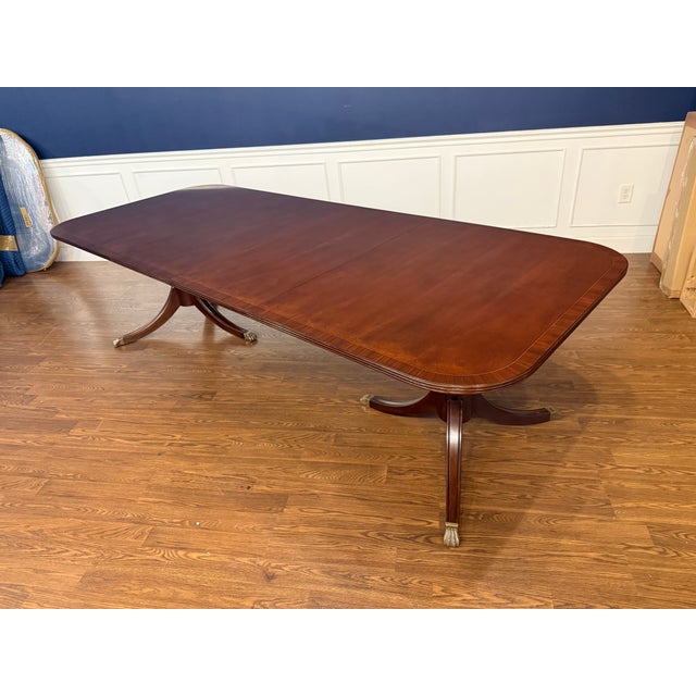 This is a classic traditional banded mahogany dining table by Leighton Hall. It features an understated field of cathedral...