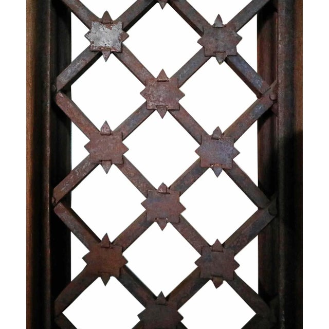 Pair of antique arched wooden double entry doors with metal grates in frame. Carved mahogany type wood has been restored...