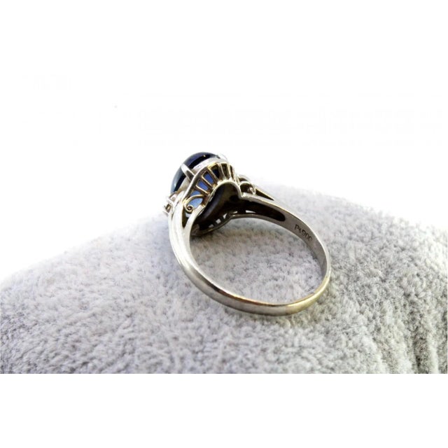 White gold ring with brilliant-cut diamonds (4) and a blue sapphire in the center in cabochon format. Metal: Gold. Origin:...