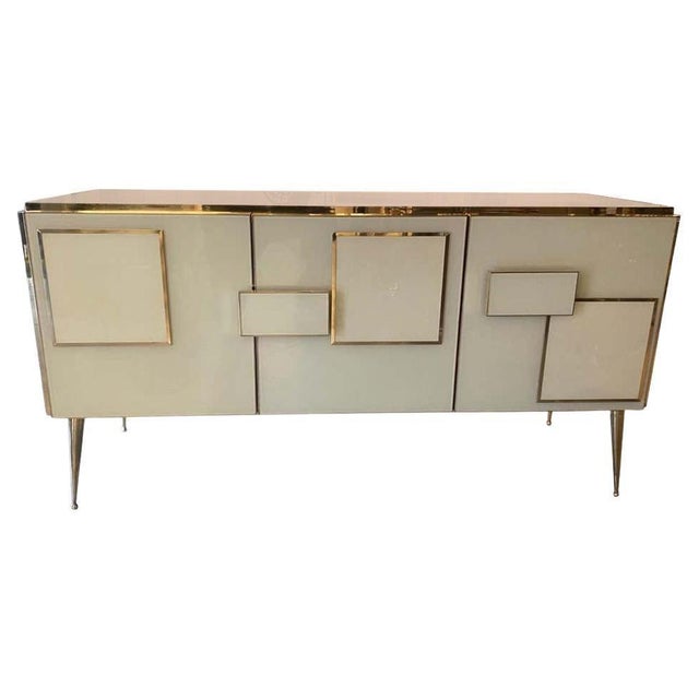 Contemporary Italian three-door sideboard handcrafted in 2026 with ivory Murano glass, solid wood and polished brass. The...