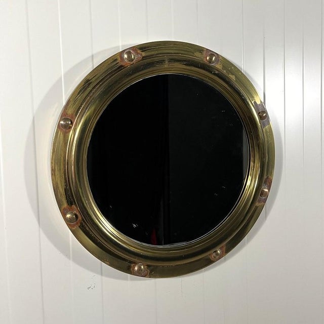 Brass porthole wall mirror by Vereinigte Werkstatten München, Germany. Brass frame in porthole design. 1950’s. In good...