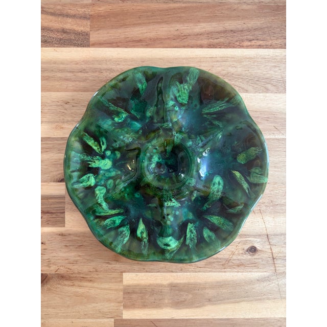 Six-well oyster plate with scalloped rim and central sauce well, covered in a mottled green flambe glaze — deep forest...