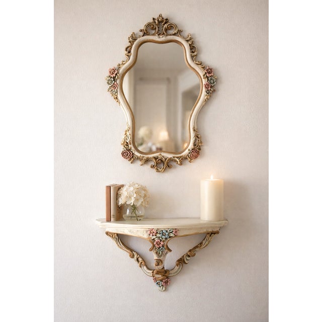 A charming vintage wall mirror with a matching console shelf, crafted in an ornate baroque style with delicate floral...
