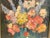 Vintage flower painting. Oil on board measures 8” x 8”. With the original frame, measures 9” x 9”. Signed illegibly lower...