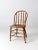 This is an antique farmhouse style dining chair circa late 19th century. The wooden Windsor chair has a turned spindle...
