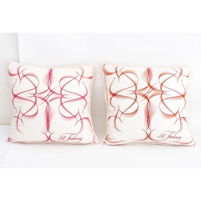 Two Hermes "24 Faubourg" Silk Pillows, in pink and red with down goose feather pillows. 25" H x 25" W x 8" D. Provenance:...