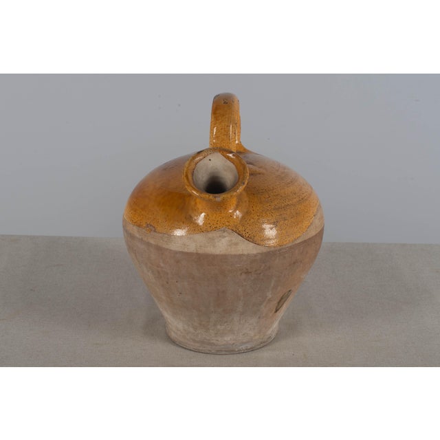 A 20th century terracotta vinaigrier, or vinegar pot, from the Southwest of France with traditional yellow glaze. In good...
