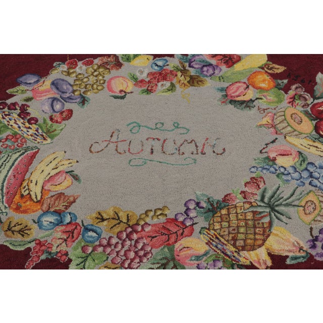 This antique 4x6 hooked rug, circa 1920–1929, features a vibrant fruit and floral wreath medallion set against a rich...