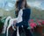 Rain King by Shelli Langdale | Oil on gallery panel Woman holding a white horse figurine among flowers. For Sale